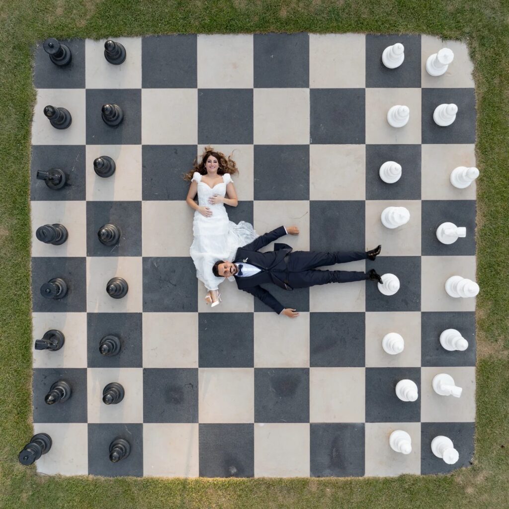 Overhead wedding portrait of a couple on a giant black and white chessboard