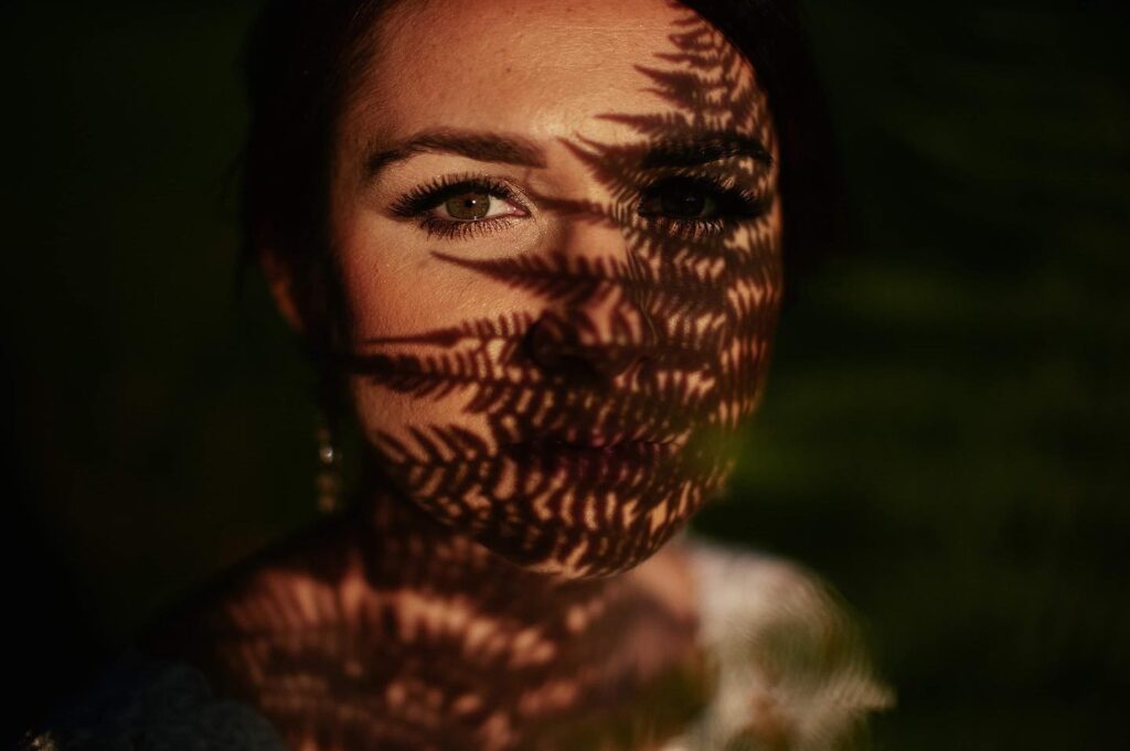 Fern shadows across a bride's face in warm light