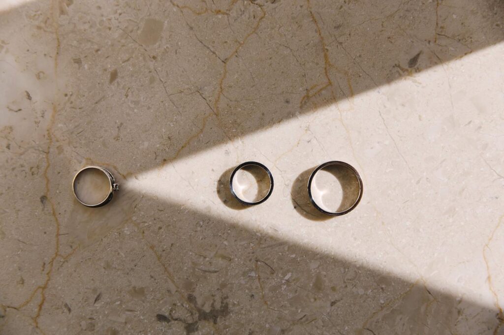 Three rings arranged on textured stone across a triangular beam of light