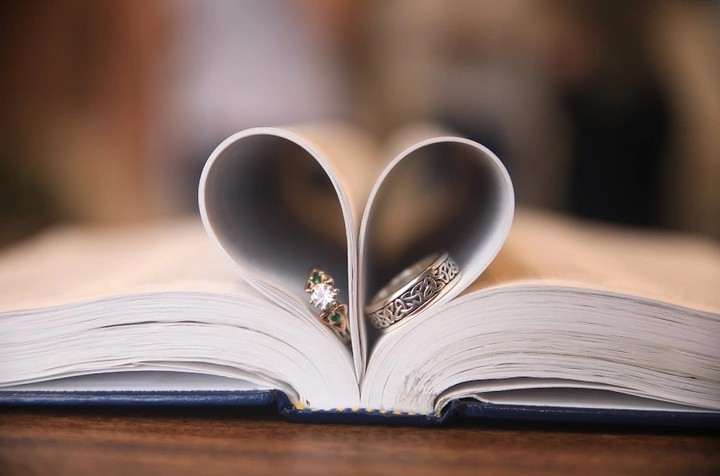 Ring nestled between book pages folded into a heart
