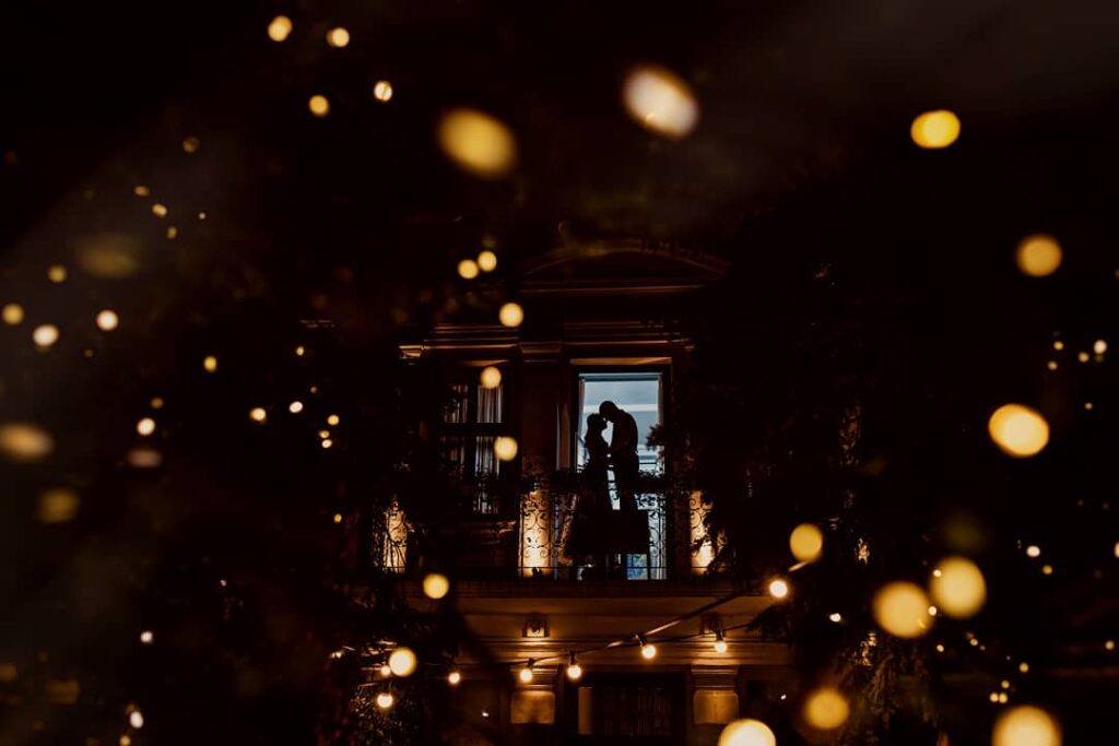 Couple silhouetted in a distant window surrounded by golden points of light