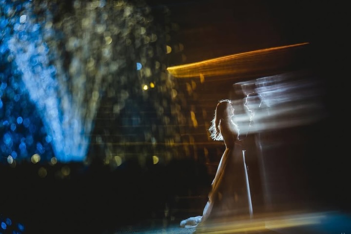 Retrato de boda con una novia rodeada por trazos horizontales de movimiento y luces azules y doradas