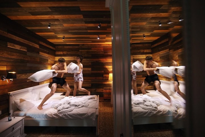 Wedding couple in a timber room with their reflections repeated in glass