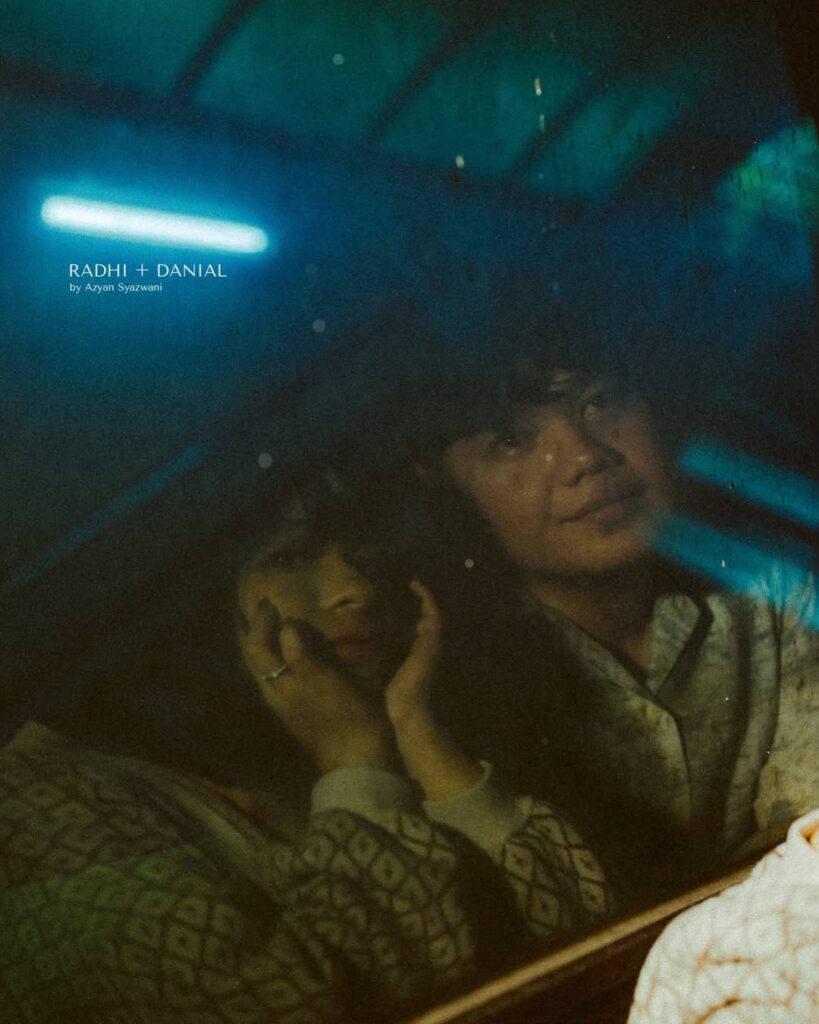 Couple seen through glass with blue light across the scene