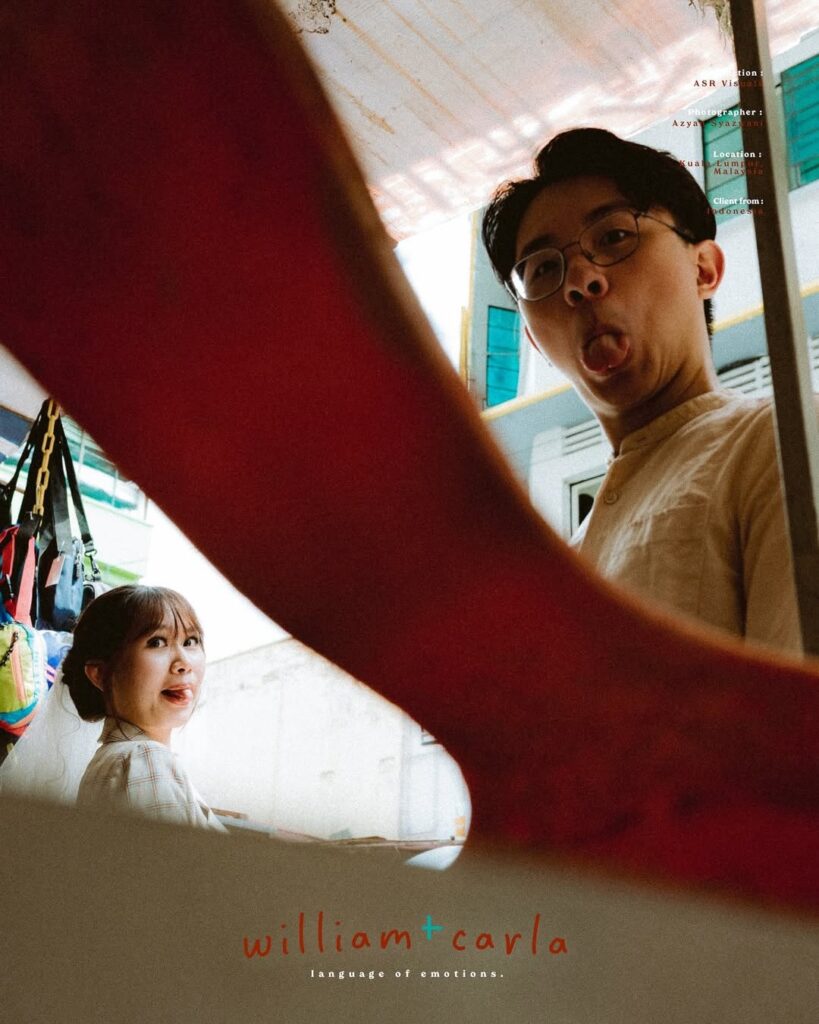 Playful couple portrait partly obscured by a large red foreground shape