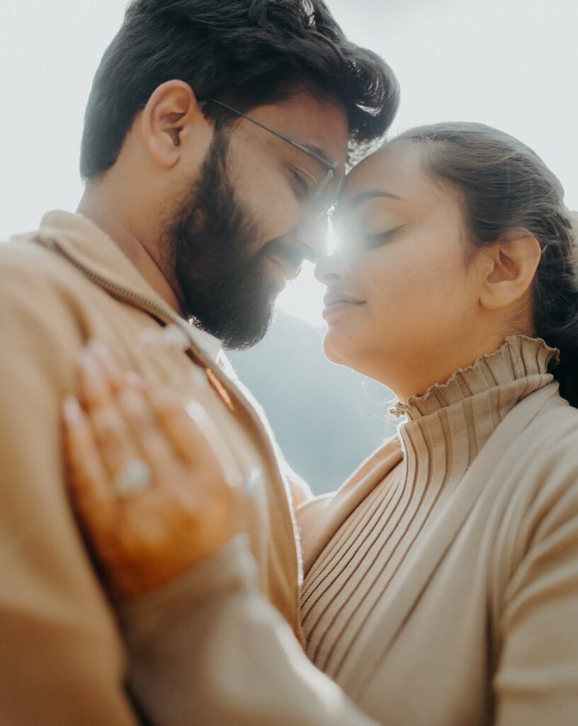 Close portrait of a couple with eyes closed and sunlight between their faces
