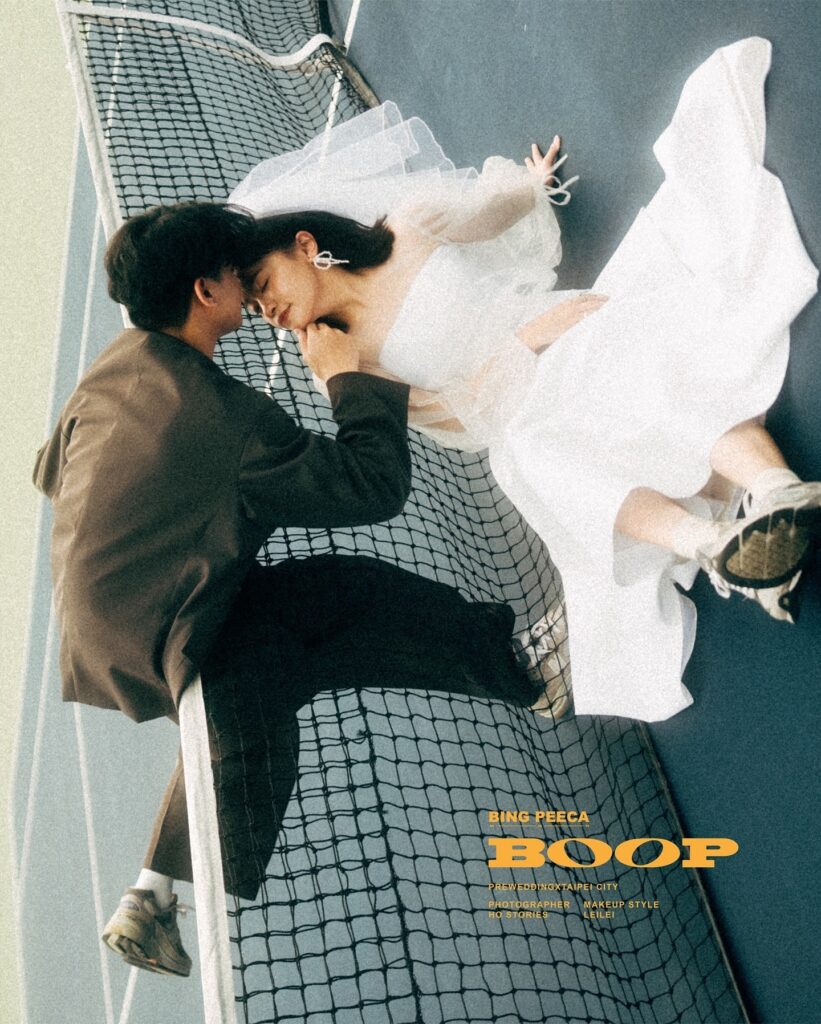 Overhead portrait of a wedding couple leaning close across a court net