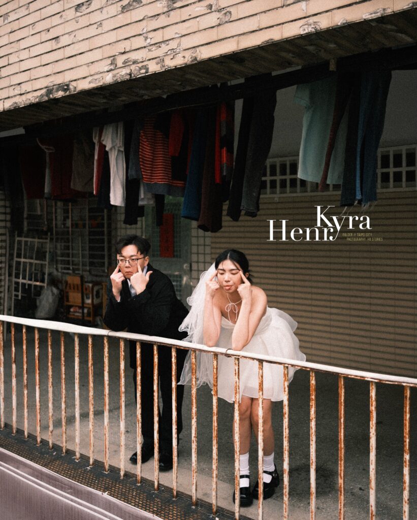 Couple leaning on a railing outside a weathered urban building
