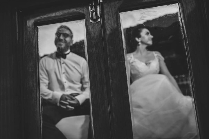 Black and white portrait of a couple seen separately in adjacent reflections