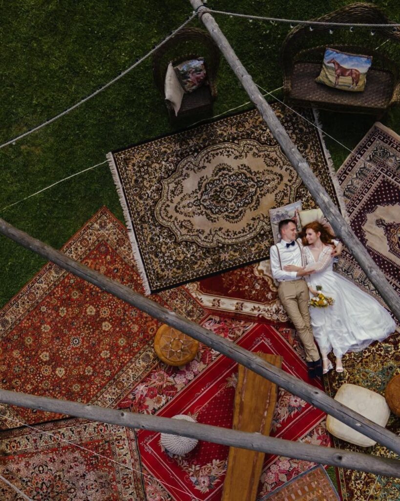 Overhead portrait of a couple lying together on patterned rugs