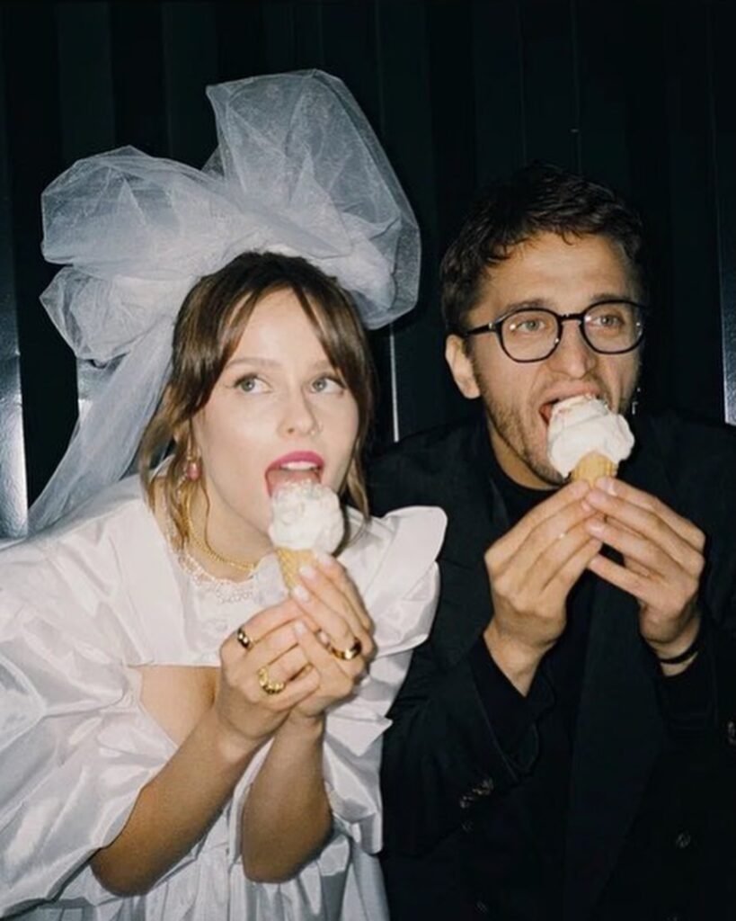 Couple holding ice cream cones in a close portrait against a dark background