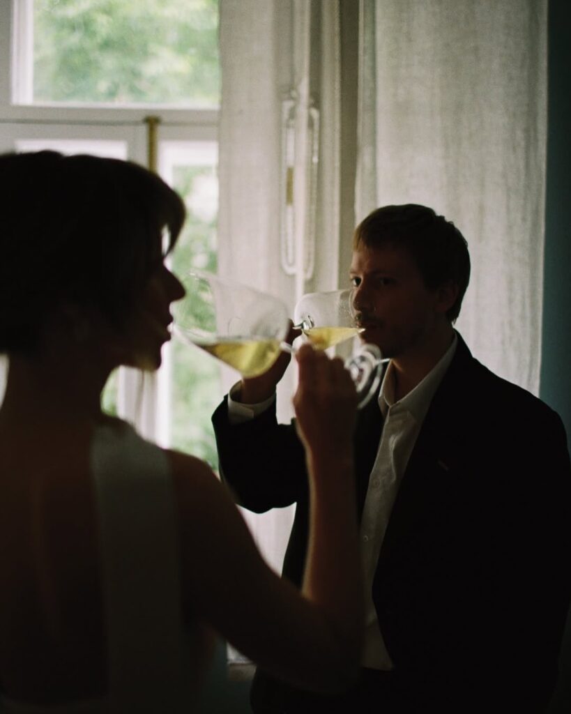 Couple sharing drinks beside a sunlit window