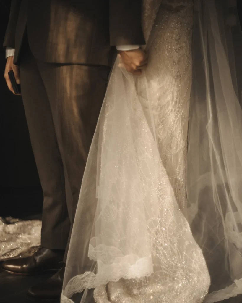 Close view of joined hands, lace fabric and a suit