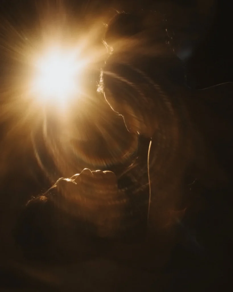 Couple holding hands with a bright golden flare behind their profiles